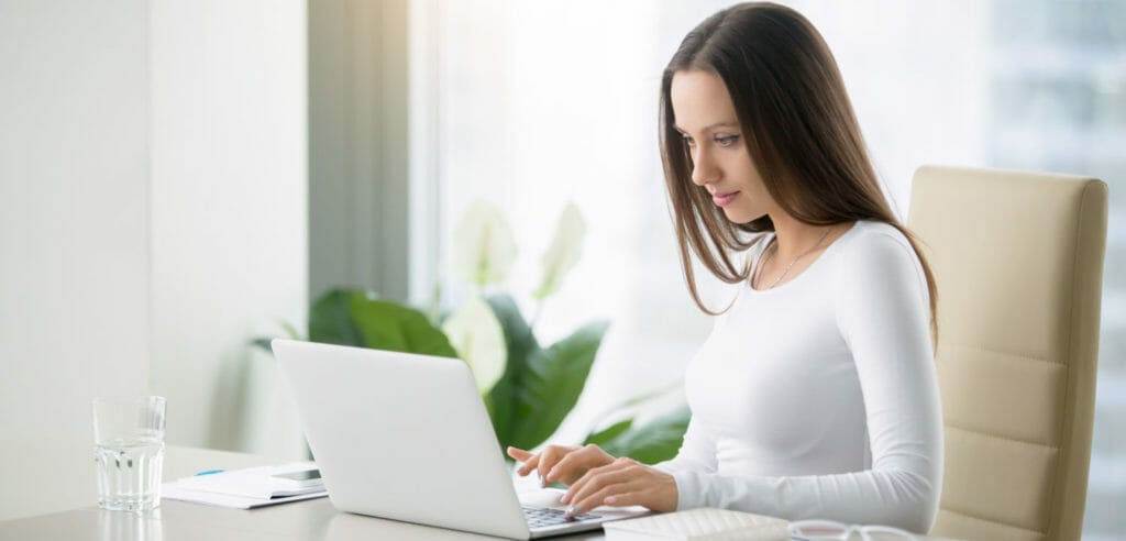 Picture of a woman on a laptop completing online surveys.